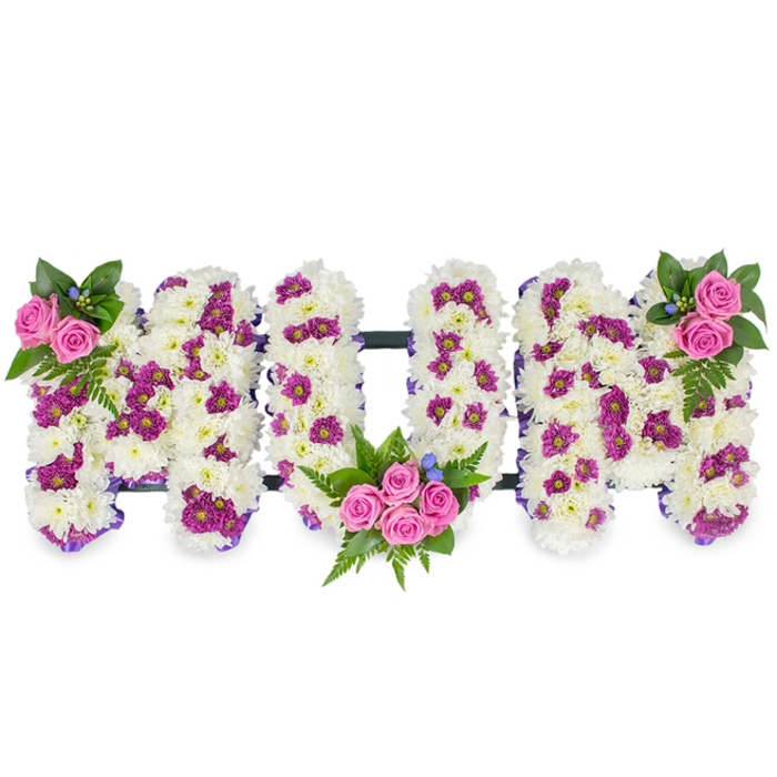 A heartfelt funeral tribute carefully composed to spell MUM in three-dimensional block letters, presented against a simple white backdrop so the floral work reads with clarity and dignity. The foundational texture of each letter is a dense mass of white chrysanthemums-small, soft-headed blooms packed together to create a plush, serene surface that feels almost like a blanket of petals. Interspersed through this white canvas are clusters of vivid purple and magenta spray chrysanthemums, introduced in a considered pattern to create contrast and to draw the eye along each letter. Charming pink spray roses punctuate the design: a modest cluster sits at the top left of the first M, a fuller bouquet of roses and foliage nestles into the interior curve of the U, and a mirrored rose grouping brightens the top right of the second M. Deep green foliage, including feathery fern sprigs and varied leaves, frames the roses and gives the composition a natural, grounded silhouette; tiny blue accent flowers provide subtle cool notes among the greens.

A narrow, dark connecting bar runs horizontally to join the letters, suggesting permanence and unity while keeping the floral focus predominant. The overall mood is tender and respectful-the cool white of chrysanthemums tempered by warm pinks and rich purples, the gentle fragrance of roses underscoring the quiet intent of the piece. Designed with the care of a neighbourhood florist familiar with the rhythms of North Watford life-from the quieter lanes near the River Colne to the community halls by Hempstead Road-this arrangement feels like a personal embrace at a funeral, wake, or memorial.