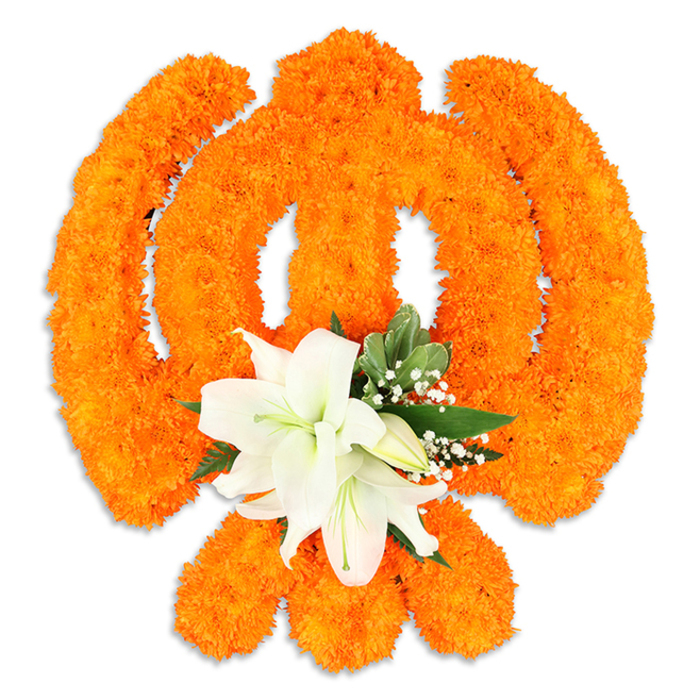 A ceremonial Khanda rendered entirely in fresh flowers fills the frame: densely packed bright orange marigolds form the symbol's definitive shapes - the chakkar's clean circle, the twin kirpans crossing behind, and the upright central khanda - their compact blossom clusters creating a richly modelled surface that both glows and casts soft shadows on the white background. At the point of intersection a refined accent of white lilies provides quiet elegance; two prominent lilies unfurl their pure, satiny petals to expose pale green-and-yellow stamens, while several smaller buds nestle in, suggesting continuity and care. Interspersed around the lilies are slender sprays of gypsophila and deep green foliage, possibly salal, which give the centre a gentle halo of texture and cool colour that balances the marigolds' warmth. Light plays across the arrangement, picking out the marigolds' fuzz and the lilies' smooth sheen, so the piece reads as both tactile and sculptural - a handcrafted offering shaped by an experienced florist's eye. This floral Khanda carries an atmosphere of reverence and celebration, frequently commissioned for Sikh observances and community events throughout North Watford - near Watford Market, by Cassiobury Park, or at local meeting places - where its colours and scent signal devotion, unity and careful floral workmanship.