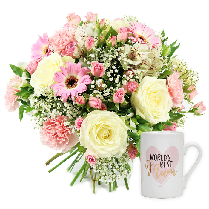 A bright, high-key product photograph showcases a sentimental floral gift set, perfect for delivery to mums around North Watford. The scene is composed on a pure white background, allowing every detail of the bouquet and mug to stand out. To the left, a generous, round hand-tied bouquet brims with texture and soft colour. Cream-coloured roses, some fully opened and others still gently cupped, reveal spiralling petals that look velvety and substantial. Ruffled blush pink carnations cluster between them, their layered edges catching light and shadow, while vivid pink Gerbera daisies with velvety, deep brown centres add a playful pop of colour and a modern focal point. Threaded lightly through the arrangement are white Alstroemeria, slender and elegant, their petals marked with fine reddish-brown flecks that provide subtle pattern. Tiny white gypsophila flowers fill the gaps, like delicate mist, softening the outlines of the larger blooms. Sprigs of fresh green foliage, in varying shapes and tones, peek through the blossoms, lending natural structure and a garden-fresh look reminiscent of flowers brought home from a local market near North Watford station. The stems are neatly gathered at the bottom in a visible bundle, confirming the hand-tied nature of the design. To the right side of the composition stands a white ceramic mug with a smooth, glossy finish and a sturdy handle. Its front is adorned with a pale, watercolour pink heart containing the words WORLD'S BEST Mum, with Mum written in an elegant metallic gold script that glows against the soft background. The clear, even lighting reveals every contour without harsh shadows, giving the whole image a calm, celebratory feel, ideal for showcasing a Mother's Day or birthday gift available for local delivery.