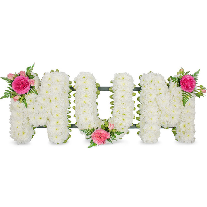 Set against a pure white backdrop, this memorial arrangement spells out MUM in bold, block capital letters, created entirely from fresh flowers. Each letter is thick with small white spray chrysanthemums, arranged so closely that no gaps are visible, giving the tribute a deep, plush texture reminiscent of a soft pillow or blanket. The chrysanthemum petals are crisp and uniform, suggesting purity and a quiet kind of grace, while a thin band of dark green ribbon or foliage lines the bases and hints at the hidden framework that supports the piece. The design is carefully balanced by three identical bursts of colour that soften the strong outlines of the letters. On the upper left of the first M, a vivid fuchsia garden rose or similar large-headed rose sits at the heart of a small posy, surrounded by several lighter pink spray roses and delicate buds. Wisps of fern foliage, with their finely cut fronds, arch and trail around the blooms, adding movement and a natural, garden-like feel. A second cluster rests at the lower centre of the U, nestled into the dip of the letter, while a third mirrors the first at the upper right of the final M. The effect is of a lovingly considered tribute that a North Watford family might place at a graveside or on a coffin to honour a devoted mother, the soft white flowers and romantic pink accents conveying gratitude, remembrance, and an unspoken thank you for a lifetime of care. Every petal and leaf works together to create a gentle, comforting focal point for moments of farewell.