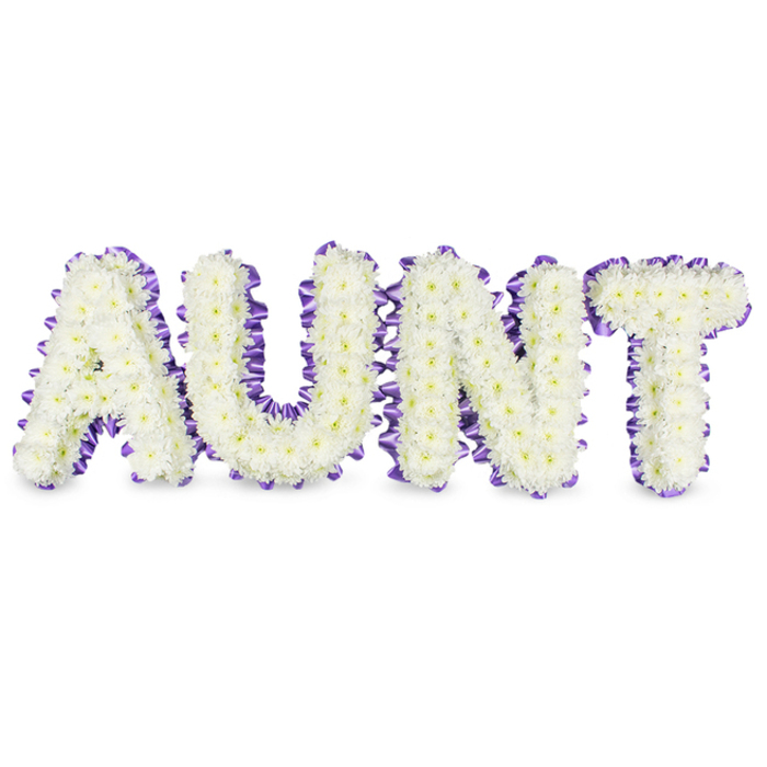A carefully composed memorial piece that spells AUNT in large, statement capitals, each letter densely packed with small, pristine white spray chrysanthemums whose tiny petals form a velvety, tactile surface. Here and there the soft yellow centres of individual florets surface like faint beacons of warmth, providing subtle contrast within the sea of white. Surrounding each letter is a bold, deep purple satin ribbon, applied as a ruffled, scalloped edge so the sheen of the satin delineates every curve and angle and gives the letters a composed, finished frame. The visual balance between the petal-soft faces of the chrysanthemums and the crisp satin borders creates a refined, respectful aesthetic. Faint grey shadows fall under and between letters on the white field, suggesting real depth and the reassuring solidity of a professionally mounted tribute rather than a flat graphic. The arrangement carries a quiet scent-clean, slightly green-and a feeling of composure; it reads as both an expression of love and a dignified response to loss. Designed for memorial services, funeral chapels, or family gatherings across North Watford - from the lanes near Watford High Street to quieter homes toward Oxhey - this floral letter tribute offers a personalised, heartfelt way to honour a beloved aunt, blending traditional sympathy flowers with tailored craftsmanship to support mourners with a visible symbol of remembrance.