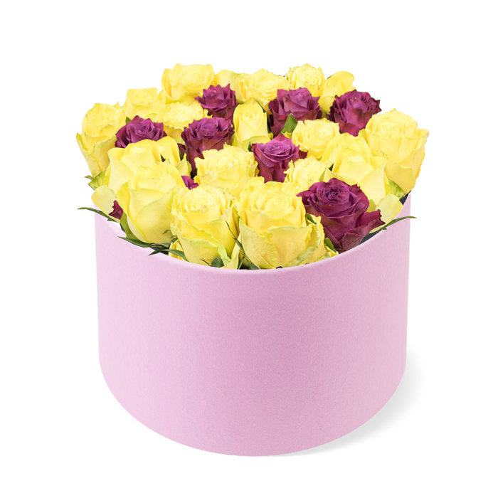 An elegant and vibrant arrangement is presented in a round pastel pink flower box, a soft touch of luxury resting against a stark white background. The box's surface feels smooth and velvety, inviting a fingertip to trace its curved edges as the blooms breathe into view. The centerpiece is densely packed with roses, primarily bright, sunny yellow blooms whose petals carry a sunny, optimistic glow. Interspersed among them are deep burgundy or purplish-red roses, providing a rich counterpoint and a sense of classic refinement. The roses are arranged tightly, filling the box completely and slightly mounding above the rim, a clear sign of abundance and expert craft. Green foliage is used modestly, allowing the brilliant hues to dominate and the box's round silhouette to shine. The image is lit to emphasize the satin-like sheen of the pink box and the velvety texture of the petals, inviting a tactile connection with the viewer. This sophisticated presentation suits elegant celebrations, premium gift occasions, or romantic gestures, and it reads well for features about luxury flower delivery and contemporary designs. Available for same-day delivery across North Watford, it's a refined expression of care that blends artistry with dependable service.
