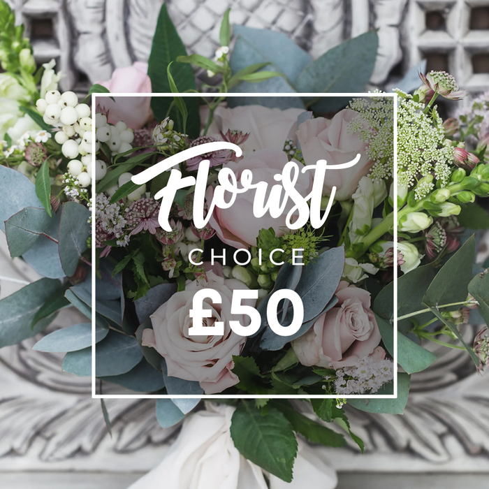 A lush, hand-tied bouquet sits proudly in the foreground against a subtly blurred backdrop of ornate, light-coloured carved stone, evoking an elegant hallway or mantel. The arrangement's focal point is a cluster of soft blush-pink roses, their petals unfurling with a romantic, tactile softness that invites a gentle touch. Interspersed among these rounded heads are bright white berries, likely snowberries or hypericum, which add crisp highlights and sculptural texture. The cooler, dusty blue-green eucalyptus leaves form broad fans and lend a silvery counterpoint to the warm rose tones, while delicate sprays of tiny white blooms - perhaps waxflower or astrantia - scatter like confetti, contributing to an airy, natural silhouette. Small deeper-pink and burgundy florets sit low in the bouquet, creating shadowed pockets that give the composition depth. Taller, slender spikes peek from the left and right, breaking the roundness with graceful vertical lines. A cream fabric ribbon binds the stems, its soft knot visible and reinforcing the handcrafted feel. Overlaid on the image is a clean white rectangle carrying script text that reads Florist above the word CHOICE and a clear price displayed as £50, signalling a curated, value-led option. Captured in gentle ambient light, the bouquet radiates calm refinement - a considered choice for wedding guest tables, elegant birthday gifts, or a refined new-home present for friends in the North Watford and Watford Junction area.