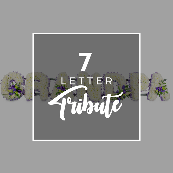 Set against a soft, even grey background, this image focuses on a dark grey square in the middle, neatly outlined with a narrow white border that creates a quiet frame within the frame. In the centre of this square, bright white text announces 7 LETTER Tribute: the numeral 7 stands tall at the top, LETTER sits just below in a smaller, straightforward font, and Tribute is written larger in a flowing script that adds a gentle, personal touch. Around and behind this square, the eye catches a seven-letter floral display spelling GRANDMA, the letters running almost like a garland across the composition. Each character is carefully shaped from a dense bed of white chrysanthemums, their tiny petals layered tightly so the letters look plush and full, as though they could cushion a final whispered goodbye. Scattered thoughtfully through the white base are little clusters of deep purple flowers, perhaps lisianthus or spray roses, mingled with glossy green leaves that curl naturally between the blooms. On the left, the entire G can be seen, the curve packed with petals and accented by a small spray of purple and greenery; as your gaze travels right, parts of the R, A, N, D, M and final A reveal themselves from behind the central text panel. The effect is of a personalised funeral flower tribute for a much-loved grandmother from the North Watford area, something you might see resting near the coffin or at the front of a service. It quietly captures the care of an experienced local florist, who understands how important it is for families to spell a name in flowers when words alone do not feel enough.