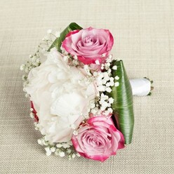 This North Watford bouquet is a true celebration of delicate craftsmanship and wedding-day warmth. Three lush roses steal the scene with their velvety petals, each unfurling in a spiral from a fuchsia rim through blush-pink transitions to a tightly wound, lavender-tinged center. At the heart, a voluminous, creamy white peony presides-its ruffled, cloud-soft petals reminiscent of early summer blooms seen along Cassiobury Park. Baby's breath is scattered for a lighter-than-air finish, each tiny blossom like a whisper of affection, bridging the striking contrast between the vibrant roses and airy peony. Deep emerald green leaves, broad and artfully folded, cradle the blooms in a neat collar, framing the entire display and enhancing the saturated colours. A smooth white satin ribbon secures the ensemble, making the handle comfortable, refined, and ready for a wedding ceremony or intimate garden gathering in North Watford. Laid on a neutral linen background, the bouquet's palette and textures come alive in gentle, even light. Every petal shines with care, freshness, and the skilled touch of a local florist-a fitting tribute to love stories unfolding nearby, and perfect as a bridesmaid's bouquet or a romantic statement for local celebrations.