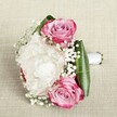 This bridal bouquet from North Watford exudes romance and heartfelt craftsmanship, each floral element thoughtfully chosen and arranged with a touch of local expertise. Swaths of ruffled white peonies take centre stage, their lush, creamy petals layered in voluminous waves that capture soft, natural light. On either side, bright pink roses unfurl in elegant spirals, their fuchsia-tinged edges melting into warm blush and subtle lavender at the core-a blend of hues echoing the cheerful spirit of North Watford's neighbourhood gardens. Wispy clouds of baby's breath thread delicately among the main blooms, lending an airy, almost fairytale-like texture and highlighting the bouquet's softness and hopefulness. Broad, glossy emerald leaves-folded and wrapped into a structural base-become the bouquet's verdant frame, ensuring that each blossom stands out with striking clarity. The stems are gathered and bound with a simple, lustrous white satin ribbon, forming a graceful handle ready for any bride or bridesmaid. Resting on a neutral, textured linen background, the bouquet radiates warmth, freshness, and a timeless elegance, making it ideal not only for weddings in North Watford but also for anniversaries, engagements, or special celebrations that call for a momentous, locally inspired arrangement.