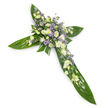 A solemn, elegant floral cross photographed on a stark white background from a gentle overhead angle so every contour reads clearly. The structural form is built from broad, glossy tropical leaves-think Ti leaves-with a deep verdant sheen and visible central veins that form the horizontal and vertical arms of the Christian cross. At the intersection and running along each arm a dense, layered spray of soft white and creamy ivory blossoms rests on that green foundation: ruffled lisianthus with multiple delicate petals and unopened buds, mixed with small, daisy-like spray chrysanthemums that add tiny, bright points across the composition. Interspersed among them are fine sprays of pale lavender or light purple star-shaped blooms-limonium or small asters-that give a quiet, cool counterpoint to the creams and whites. Smaller slivers of fine green filler foliage are threaded through the clusters, softening edges and lending a natural, meadowlike texture against the smooth, waxy leaves. The lighting is even and soft, bathing the arrangement in a calm, nearly spiritual glow that highlights petal detail and the wet-look sheen of the leaves without harsh shadows. There is a whisper of fresh, green scent suggested by the foliage rather than an overpowering perfume, a subtle olfactory note appropriate for moments of remembrance. Crafted with restraint and respect, this cross reads as a traditional sympathy tribute-suitable for funeral services, a church memorial or graveside tribute in North Watford-and offers a dignified, peaceful expression of condolence and hope.