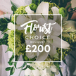 An opulent, high-end Florist Choice Bouquet takes center stage, its white lilies gleaming beside playful lime-green accents that lift the arrangement with contemporary energy. The large lilies dominate with soft, gleaming petals, while clusters of small white blooms-ranunculus or spray roses-add feathered texture and poise. The lime-green elements-dense and tactile-resemble Green Trick dianthus or compact hydrangea heads, delivering a striking brightness that feels both fresh and premium. Dark, velvety foliage weaves through the display, anchoring the bouquet in a garden of depth and scent. The bouquet appears to be held by a person, their light attire softly softened by a shallow backdrop, suggesting a moment captured before a wedding or a formal event. A crisp white rectangular frame sits at the image's center, bearing the label Florist Choice Bouquet in a graceful script, with bold uppercase text and the price ?200 finishing the frame. This luxurious composition is a signature offering from Flower Delivery North Watford, available for delivery across the North Watford area, with options for same-day service to suit last-minute celebrations and thoughtful gifts alike. The overall mood is serene yet radiant, a design that communicates care, craftsmanship, and a confident flair for contemporary elegance. It's the kind of bouquet that whispers of anniversaries, late-afternoon receptions, and joyful gatherings, thoughtfully assembled by a local team attuned to the rhythm of North Watford's calendar and needs.
