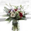 A celebration of balance and individuality, this North Watford-inspired bouquet blends velvety crimson roses with creamy white gerberas, their brown centers echoing the tones of a freshly brewed morning coffee along Whippendell Road. Soft, pastel-hued lisianthus blooms-some in full flower, others budding-add a delicately wistful presence. Streams of eucalyptus sweep outward, their silvery-green discs catching the morning light, imparting not just visual interest but a cool, invigorating scent reminiscent of North Watford's leafy avenues. The arrangement is grounded by lush, sculptural foliage; glossy, deep green leaves that cradle the blooms, highlighting the bouquet's abundant freshness. Nestled within, tufts of petite ivory filler flowers cluster like pearls, adding depth and gentle texture. This bouquet's overall mood is both soothing and uplifting, making it ideal for expressing thanks, celebrating milestones, or simply bringing a smile to a neighbor's doorstep. Each stem, expertly curated and arranged, carries with it a sense of heartfelt connection and the timeless beauty found in everyday North Watford moments.