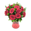A lush, romantic bouquet of around twelve to fifteen deep red roses stands proudly in a translucent red glass vase, set against a pure white studio background that makes every petal glow. Each rose is fully open yet still fresh, its velvety petals curling into perfect spirals that create a cushion of rich, ruby colour. The roses are arranged in a classic, rounded dome, the blooms touching and overlapping so that no gaps break the luxurious, full effect. Nestled between the flowers is a generous layer of dark, glossy greenery, likely ruscus, the pointed leaves fanning out just enough to frame the roses without stealing the spotlight. Their deep green tones heighten the intensity of the crimson, giving the bouquet a sense of depth and movement, like a gentle wave of foliage supporting a sea of roses.

The red glass vase has a softly flared rim and a gently curving silhouette that narrows towards the base, its subtly ribbed or swirled texture catching the light in fine highlights and shadows. Because the glass is translucent rather than opaque, hints of the stems and varying shades of red can be seen within, tying the container to the flowers above in a harmonious flow of colour. Lit with bright, even lighting, the arrangement feels timeless and elegant, a modern studio portrait of classic romance. The scene could easily be imagined on a side table in a North Watford townhouse, or delivered as a passionate anniversary surprise to a home near Cassiobury Park, the roses radiating warmth, devotion, and that unmistakable feeling of being deeply cherished.

This image conveys the essence of a traditional red rose bouquet: simple in idea, but expertly crafted and rich with emotion.