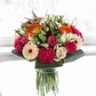 This bouquet brings the effervescent spirit of North Watford indoors-a celebration composed in vibrant blooms and skillful hands. Spirited orange gerberas radiate positivity, their lively centres catching bright light much like a sunrise over Watford's gardens, while soft pink roses and voluptuous magenta carnations offer tenderness and rich texture to the ensemble. Creamy ivory roses and delicate peach gerberas soften the overall design, adding elegance and hinting at the quiet beauty found along the neighborhood's winding lanes. Framed with lush, glossy greenery, each bloom is accentuated and stabilized, echoing the welcoming abundance of communal spaces in North Watford. The sunlight streaming through highlights every gentle curve and velvety edge, making the colours seem almost to dance. Ideal for commemorating milestones or simply to uplift a loved one nearby in North Watford, this arrangement feels like a burst of happiness-expertly composed to deliver harmony, freshness, and joy with every petal.