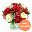Set against a bright white background, this bouquet of red and white roses looks like it has just been styled on a florist's bench before heading out for delivery to a North Watford address. The arrangement brings together lush, deep red roses and soft, creamy white roses, each blossom fully open so their velvety petals can be appreciated in layers. Between the larger blooms, delicate bunches of tiny, bright red filler flowers, reminiscent of dyed gypsophila, create a misty veil of colour that softens the transitions and gives the design a celebratory sparkle. Glossy red hypericum berries nestle among the petals like drops of lacquer, adding round, textural accents that stand out against the smooth rose petals. Surrounding everything is a generous collar of greenery, with rich green leaves and slender eucalyptus sprigs adding fullness, structure, and a faint silvery tone that cools the vibrant reds. The flowers are arranged in a clear, rectangular glass vase, allowing the stems and water to be seen and lending a simple, modern touch that fits beautifully on coffee tables, office desks, or restaurant counters around North Watford. Around the middle of the vase, a cheerful green and white gingham ribbon is wrapped in a neat band, introducing a rustic, homely feel that suggests comfort and warmth. In the lower right corner of the image sits a bold orange circle with the words VASE INCLUDED in crisp white capitals, clearly indicating that the arrangement is delivered complete and ready to enjoy. The overall mood is one of joyful romance and thoughtful care, suited to birthdays, anniversaries, or spontaneous gestures of appreciation.
