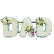 A large, three-dimensional DAD funeral tribute stands out clearly against a bright white background, the kind of arrangement often ordered from Flower Delivery North Watford to accompany a final farewell. Each letter is completely enrobed in tightly packed white chrysanthemums or similar button flowers, laid in careful rows so the surface appears lush, even, and softly textured, like a white blanket of petals. Around the very edge of each letter, a ruffled emerald green satin ribbon has been meticulously pinned, its pleated folds catching the light and echoing the fresh greens seen in local parks and gardens around North Watford. The letters are fixed to a subtle dark framework with horizontal bars that are just visible from behind, confirming that the tribute is designed to stand upright, perhaps in front of the coffin or beside family wreaths. To soften the structured blocks of white, the florist has added small accent sprays: on the top left of the first D, a neat cluster of white freesia and glossy foliage, and on the upper right of the final D, a complementary grouping of the same flowers and greenery. Connecting the first D to the central A, two slender green stems curve gently across the arrangement, leading into a more dramatic focal piece. Here, two deep purple calla lilies unfurl their elegant, trumpet-shaped blooms amid additional white flowers and leaves, their rich colour adding a note of quiet intensity and solemn beauty. The overall composition feels calm, respectful, and deeply personal, a floral tribute that speaks of love, gratitude, and cherished memories of a father within the North Watford community.