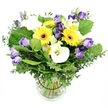 From the window of our North Watford studio, this lush, vibrant bouquet is arranged in a clear glass vase against a pristine white backdrop that makes every hue leap with clarity. The cheerful mix feels balanced and contemporary, like a sunlit garden brought indoors. At the heart of the arrangement, sunny Gerbera daisies blaze in bright yellow, their large faces accented by distinct dark centers that act as bold anchors. They are interwoven with clusters of Lisianthus in lavender and pale purple, some fully open to reveal ruffled edges while others hover in elegant buds, adding velvety layers and gentle movement. White Calla lilies make a crisp counterpoint, their smooth curved spaths contributing architectural grace. Interspersed there are Alstroemeria, or Peruvian lilies, in pristine white with subtle streaks of yellow or green that catch the light. The lush greenery grounds the arrangement: slender eucalyptus branches in silvery-green provide a softly aromatic backdrop, while broad, verdant leaves give volume and contrast to the bright blooms. The stems are visible through the clear vase, neatly bound by a discreet dark tie that keeps the arrangement tidy and cohesive. It's a design that feels both fresh and refined, ideal for a birthday, a note of congratulations, or simply to brighten a home in North Watford.