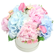 In a pristine white round hatbox, a luxurious, abundant bouquet unfurls with a quiet, confident opulence. Soft pastel pinks and powder blues mingle in perfect balance, the main stars being velvety, oversized peonies with their many delicate petals and cloud-like clusters of light blue hydrangeas. Interwoven among them are pale pink spray roses, their small, tightly furled blooms adding texture, and two striking trumpet-callas in a deeper rose pink that rise gracefully above the rest, one near the top-left and another peeking from the bottom-right. A touch of subtle greenery--hydrangea leaves and the soft shimmer of dusty miller--frames the arrangement with depth and restraint. The bouquet is sculpted into a full, rounded dome, each stem tucked with care to create a seamless, luxe silhouette. The scene is set against a pure white backdrop, making the colors sing and underscoring its aura as a refined gift, a centerpiece, or a heartfelt celebration piece. I imagine this arrangement brightening a North Watford living room, perhaps perched beside a window overlooking Cassiobury Park, its gentle fragrance weaving with morning light and a cup of tea. This bouquet speaks of birthdays, anniversaries, baby showers, and gender reveals, whispering romance and quiet sophistication. The craftsmanship is evident in the dome's symmetry, the careful spacing of spray roses, and the way two calla lilies curve like ribbons above the blooms. Delivered fresh, with pristine stems and secure packaging, it promises not only beauty but a lasting memory for the recipient and the giver alike.