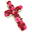 A striking floral cross arrangement is displayed on a flawless white background, drawing the eye immediately to its rich tapestry of red and pink roses. The entire cross-both the tall central stem and the shorter horizontal arms-is densely covered with large, velvety deep red roses, each blossom open wide and layered in spirals that give the surface a plush, almost silk-like appearance. Woven between these crimson blooms are generous clusters of vivid fuchsia pink roses, their softer, more ruffled petals bringing a gentle sense of movement and a touch of uplifting colour to the solemn design. Scattered throughout, small rosebuds in coordinating tones of red and pink offer delicate accents and a feeling of life still unfolding. Carefully framing this sea of roses is a slim, even border of tiny white flowers, likely spray chrysanthemums or miniature carnations, which creates a crisp, glowing outline and reinforces the sacred cross shape. Subtle glimpses of fresh green foliage and fine green ribbon break through at the edges, grounding the design in nature and suggesting the care of a skilled local florist. The overall lighting is bright yet soft, showing every nuance of colour and texture without casting harsh shadows. Crafted as a meaningful sympathy tribute for funerals, memorials, or church services in North Watford and the surrounding areas such as Callowland and Tudor, this floral cross conveys a blend of reverence, love, and gentle peace, offering a beautiful, comforting focus for family and friends gathering to remember someone dear.
