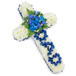 A carefully crafted floral cross for a father's funeral is pictured against a simple, bright white background, allowing the colours and textures to convey the emotion of the tribute. The main body of the cross is made from countless small white spray chrysanthemum heads, each bloom freshly opened and placed tightly together to form a thick, cushion-like layer that softens the hard lines of the cross. Around the perimeter, a royal blue satin ribbon is neatly ruffled and pinned, encircling the white flowers with a smooth, lustrous frame that catches the light and gives the design a refined, formal edge. At the central crossing point, a vibrant cluster of royal blue flowers acts as the focal feature, composed of plush blue carnations and delicate, upright blue florets reminiscent of delphinium or orchid blossoms. These are surrounded by rich, dark green fern fronds and complementary foliage, bringing a touch of natural woodland calm that local families in North Watford might associate with nearby green spaces. Along the upright stem of the cross, just below the central spray, the word DAD appears, not printed but sculpted from the same royal blue ribbon, each letter shaped by hand and laid gently onto the white chrysanthemum surface. This intimate detail transforms the piece from a general Christian cross into a deeply personal message of love and gratitude. The overall design feels serene, respectful, and deeply heartfelt, a fitting floral tribute to accompany a father's final journey and to bring a sense of comfort to mourners gathered in quiet reflection.