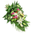 This heartfelt cascading bouquet is a floral tribute that captures the spirit of North Watford with each carefully selected bloom and verdant leaf. The focal point is a collection of white lilies, some blossoming with radiant, golden-centred petals, others in serene bud. Nestled beside them, fuchsia and deep pink roses add layers of emotion, intertwining remembrance with love's gentle embrace. White spray carnations, delicate and ruffled, lend textural contrast and soften the overall composition. Bright green santini chrysanthemums spring forth, offering a fresh, moss-like vibrancy that echoes the garden life found near Verulamium Park. Red hypericum berries are scattered thoughtfully, their pops of scarlet animating the bouquet and bringing moments of cheerful colour among the greenery. An array of lush, glossy foliage forms a strong visual backbone: broad dark leaves, finely folded, create lines of structure, while palms and lighter fronds cascade gracefully to one side, suggesting movement and natural grace. The entire arrangement, resting on a pristine white canvas, radiates calm and compassion-a fitting expression for occasions of remembrance or saying farewell. Each detail reveals the skill and sensitivity of North Watford's florists, transforming flowers into a story of peace, dignity, and enduring care.