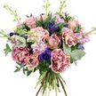 A lavish hand-tied bouquet is set against a spotless white backdrop, every detail illuminated as though showcased in the window of a North Watford florist on a bright day. At the heart of the arrangement, roses in soft dusty pink, muted mauve, and gentle peach unfold in varying stages, from tight buds cradling hidden petals to fully open blooms with deep, swirling centres. Surrounding them, voluptuous carnations enhance the bouquet with their signature ruffled texture; each petal tip glows in shades of vivid magenta that gradually melt into creamy blush tones towards the middle, giving the whole design a layered, painterly feel. Interspersed among these romantic flowers, rich indigo and violet-blue anemones stand out boldly, their near-black centres adding a sophisticated contrast that instantly draws attention. Rising gracefully through the rounded form of the bouquet, stems of lavender and pastel pink stocks carry long columns of tiny clustered flowers, bringing a light, feathery softness and the suggestion of a powdery, nostalgic fragrance. Lush greenery frames the blooms: rounded, silvery eucalyptus leaves mingle with darker, broader foliage, creating a cool, leafy collar that enhances the pastel shades and echoes the calm of North Watford's residential gardens. The stems are clearly visible and hand-tied at the base, neat yet natural, highlighting both freshness and expert craftsmanship. Bright, even lighting reveals the velvety surface of the roses, the frilled edges of the carnations, and the satiny petals of the anemones in clear detail. The overall mood is one of gentle luxury and contemporary romance, perfectly suited to celebrating milestones, sending thanks, or simply brightening a North Watford living room or office with elegant floral colour.