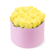 A luxurious hat box arrangement of yellow roses is showcased against a spotless white background, offering a clear view of its modern, romantic style. The round box is a delicate pastel pink, with a smooth, matte surface that suggests a soft, velvety finish beneath the fingertips. Its simple cylindrical shape acts as a graceful frame for the abundance of roses rising from within. The blooms themselves are tightly massed to form a gentle, domed surface that just crests above the box's edge, like a carefully sculpted hill of petals. Each rose displays layered, velvety petals in shades of warm yellow, from pale buttery interiors to more vivid outer edges, evoking feelings of happiness, friendship, and gentle encouragement. Tiny glimpses of green foliage peek through here and there, hinting at the stems below while keeping the visual focus firmly on the yellow blossoms. The entire composition is evenly lit, with light falling softly across every petal so that there are no harsh contrasts, only a serene, luminous quality, as if the bouquet were sitting in a calm North Watford studio near St Albans Road just before being dispatched for delivery. This floral hat box would feel at home on a dining table in a flat overlooking Cassiobury, on a bedside table after a birthday surprise, or on a reception desk welcoming visitors to a local business. It conveys quiet celebration and refined taste, a compact burst of sunshine thoughtfully arranged within a pretty pink box.