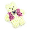 In this image, a sweet teddy bear-shaped floral tribute is presented as though it were a cherished toy made entirely of blossoms. Its rounded form is constructed from countless white and buttery-cream chrysanthemums, each flower closely nestled to the next so that the bear's body looks velvety and soft to the touch. The head is gently domed, with two ears clearly defined at the top, while the arms and legs are short and stout, giving the figure a sturdy yet cuddly stance. Two small, dark eye centres are set carefully into the face, providing a calm, soulful gaze, and a miniature black triangular nose marks the centre, hinting at the familiar lines of a teddy's snout. Around the mouth area, the thoughtful arrangement of petals subtly suggests a quiet smile, a look that feels both comforting and protective. Across the front of the bear, a vibrant vest has been created with clusters of deeper pink and lilac blooms, their richer shades forming two mirrored panels that stand out beautifully against the pale body. At the meeting point of these panels, a delicate bow of purple netting sits like a tiny cravat, its translucent folds adding movement and a playful, dressed-up feel. The bear is photographed against a plain white background with soft, even light, allowing the floral textures and colours to appear crisp and clean, without any visual clutter. This is the kind of personalised funeral or remembrance piece often chosen by families in North Watford, from Leavesden to North Orbital Road, when they wish to honour a child or baby with a symbol of innocence, warmth, and unconditional love, delivered fresh from their local florist.