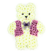 A lovingly crafted floral teddy bear tribute is displayed against a crisp white background, capturing the eye with its soft, creamy tones and tender expression. Every part of the bear-from the round ears perched on top of its head to the sturdy little feet-has been formed from small, densely packed white chrysanthemum blooms, giving the impression of plush, velvety fur. The petals curve gently outward, creating a cushioned texture that feels almost touchable, as if you could run your hand along the bear's arm and feel the cool freshness of the flowers. Darker floral centres are used sparingly yet effectively to shape the bear's eyes and button nose, lending it a gentle, reassuring gaze. Across the chest, a waistcoat made from rich purple and mauve blossoms introduces a warm contrast. The petals are arranged to suggest tailored lapels and a neat front, echoing a child's best outfit reserved for special occasions. At the neckline, a light lilac mesh bow sits like a tiny, translucent bow tie, its netting catching hints of light and adding a note of grace. Imagining this piece at a funeral service or chapel of rest in North Watford, it is easy to picture the soft floral scent mingling with hushed voices and shared memories. This teddy bear arrangement is often chosen as a sympathy tribute for a young person, or simply for someone remembered with particular tenderness, expressing innocence, love, and the wish to wrap a grieving family in comfort. Crafted with care, it becomes a quiet symbol of remembrance that feels deeply personal and heartfelt.